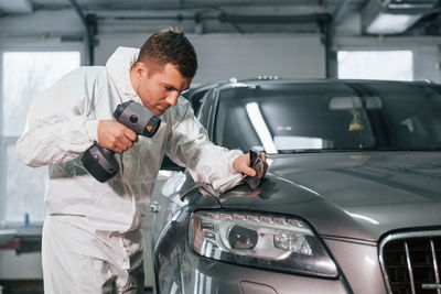 Professional worker. man in uniform is in the auto service.