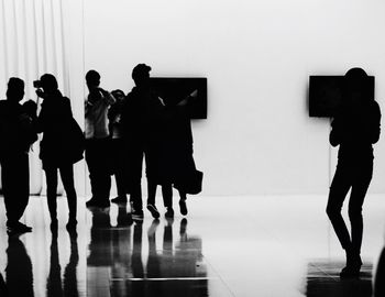 Silhouette people standing against wall