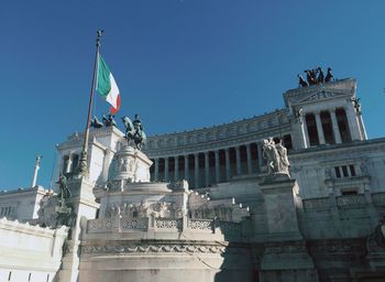 Low angle view of statues in building against sky