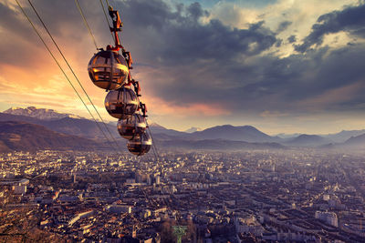 Aerial view of illuminated cityscape against sky during sunset