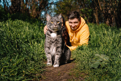 Man and cat together in grass