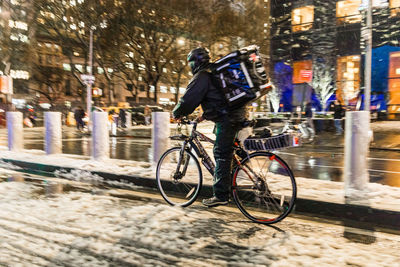 Man riding bicycle on street in city