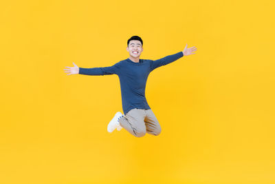Portrait of smiling man against yellow background