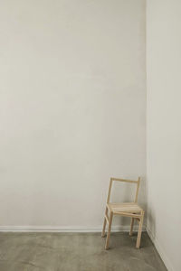 Empty chairs and table against wall at home