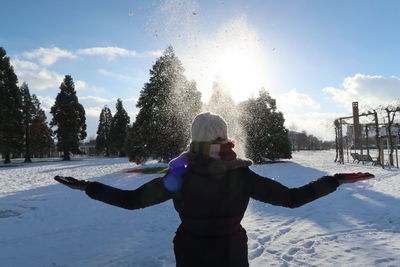 Woman standing in snow against sky during winter
