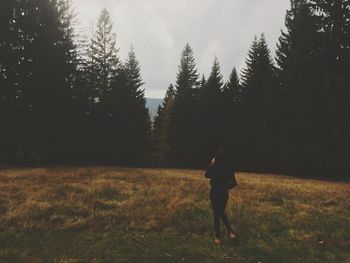 Rear view of woman walking on field at bavarian forest