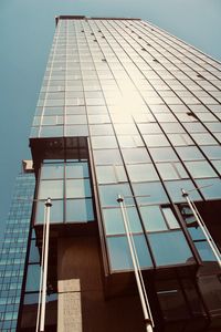 Low angle view of glass building against clear sky