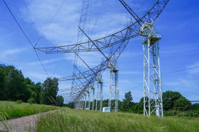 Electricity pylon on field against sky