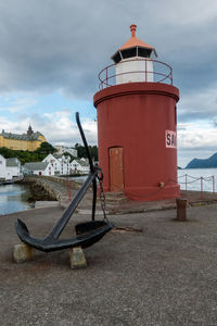 Lighthouse by sea against sky