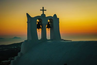 Cross by sea against sky during sunset, santorini greece 