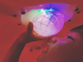 Close-up of boy holding illuminated light