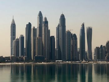 Skyscrapers by modern buildings against sky in city