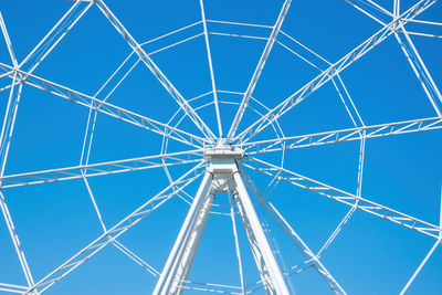 Low angle view of ferris wheel against blue sky