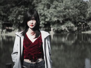 Portrait of woman standing against lake