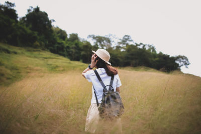 Woman wearing hat on field against sky