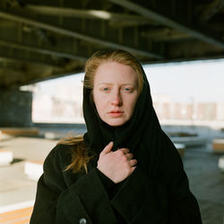 A woman stands at sunset near the bridge