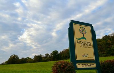 Low angle view of information sign against sky