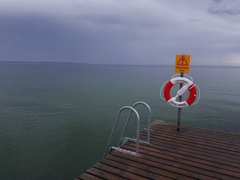 Lifeguard hut by sea against sky