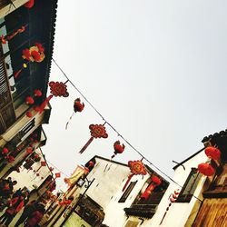 Low angle view of lanterns hanging against sky