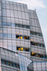 Low angle view of modern glass building against sky