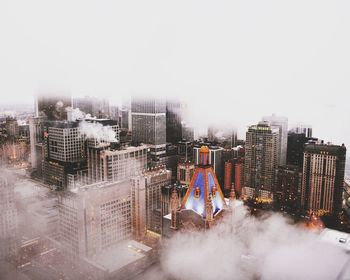 Clouds covering buildings in city