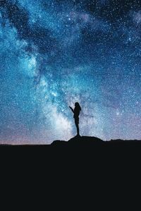 Silhouette man standing against sky at night