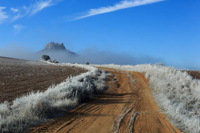 Panoramic view of dirt road against sky