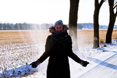 Portrait of woman standing on snow covered landscape