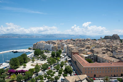 High angle view of townscape by sea against sky