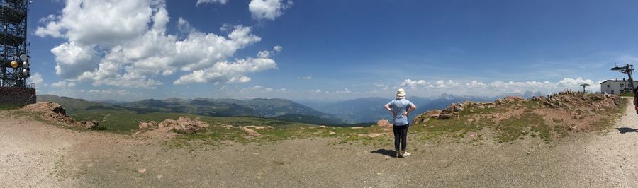 People on mountain against cloudy sky