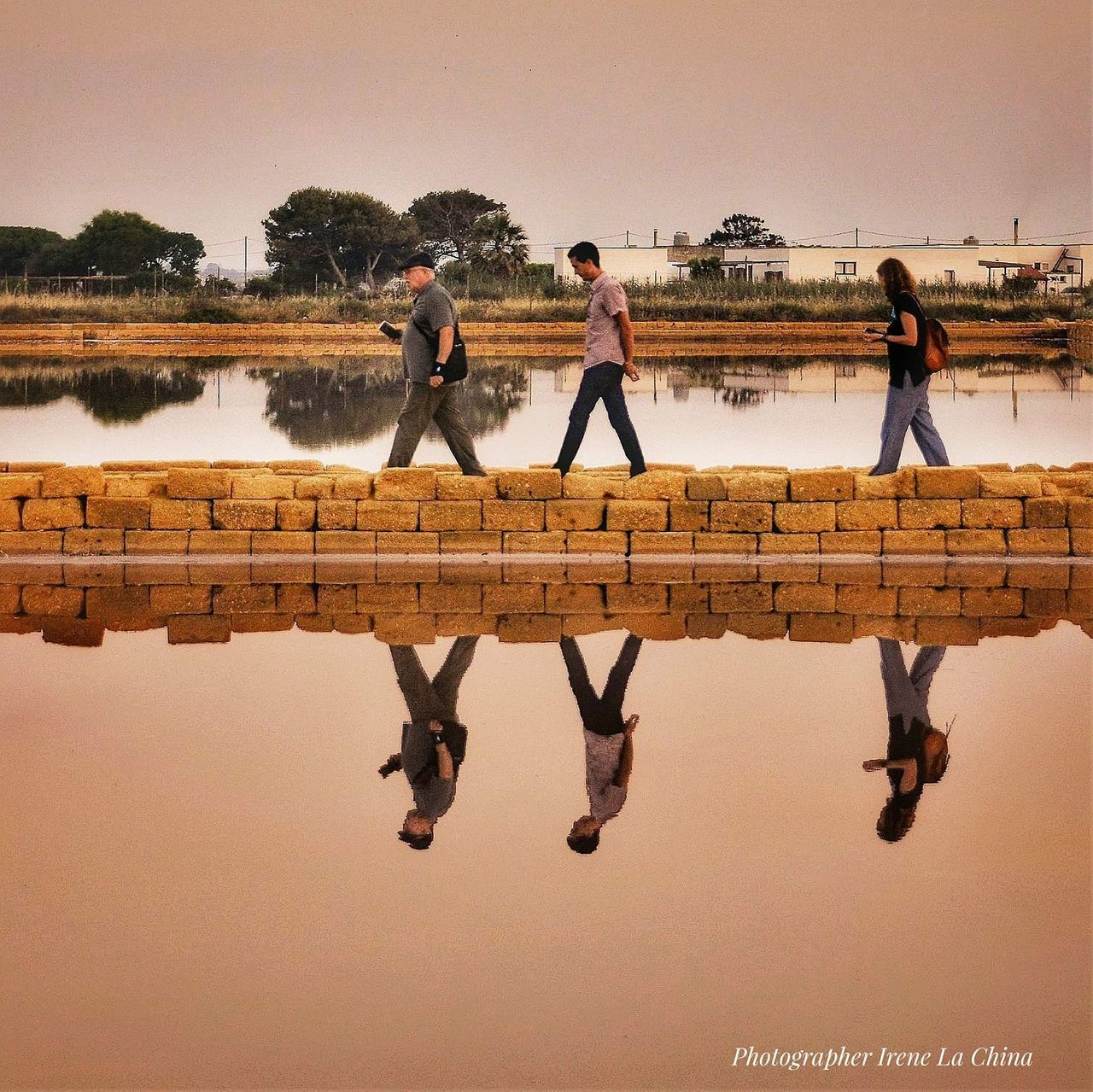 PEOPLE STANDING ON LAKE AGAINST SKY