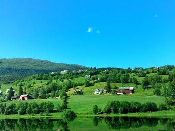 Scenic view of trees and houses against sky