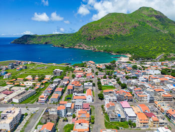 High angle view of townscape by sea against sky