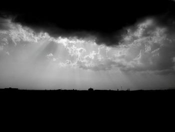 Silhouette of landscape against cloudy sky