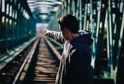 Rear view of woman standing on railroad station