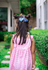 Rear view of girl with braided hair standing outdoors