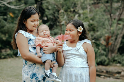 Mother carrying daughter at park