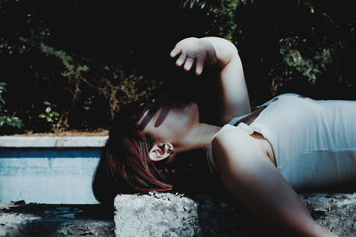 Midsection of woman sitting on tree