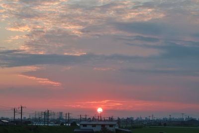 View of city against cloudy sky during sunset