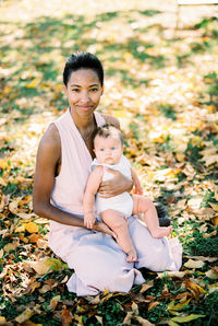 Portrait of young woman sitting on field