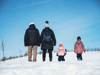 Portrait of family standing on snow slope. rear view. long shot.