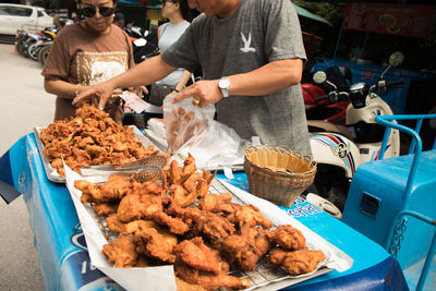 Midsection of people at market stall