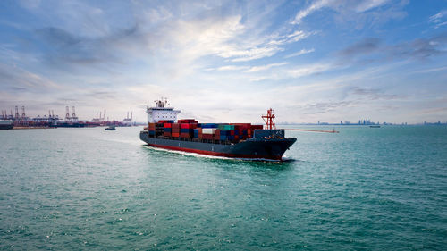 Container ship transporting large cargo logistic import export goods internationally worldwide 