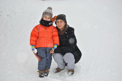 Portrait of mother with son on snowy land