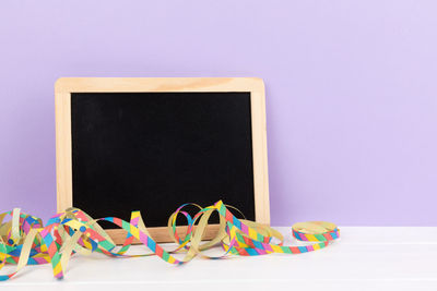 Close-up of blank slate and streamer against gray background