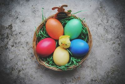 High angle view of colorful easter eggs in wicker basket on floor