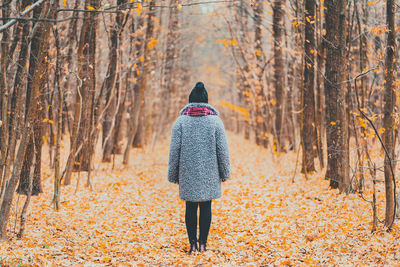 Rear view of woman walking on snow covered land