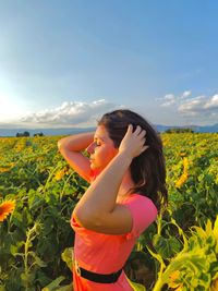 Portrait of young woman standing against sky