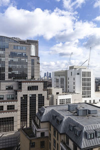 Buildings in city against cloudy sky