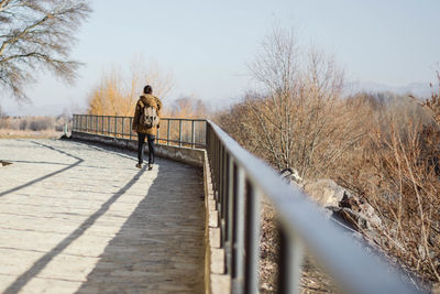 Rear view of woman walking on bridge